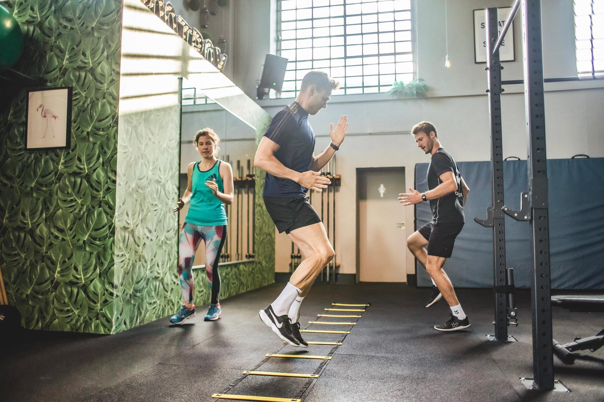 Kursteilnehmer an der Koordinationsleiter im Fitnesskurs.