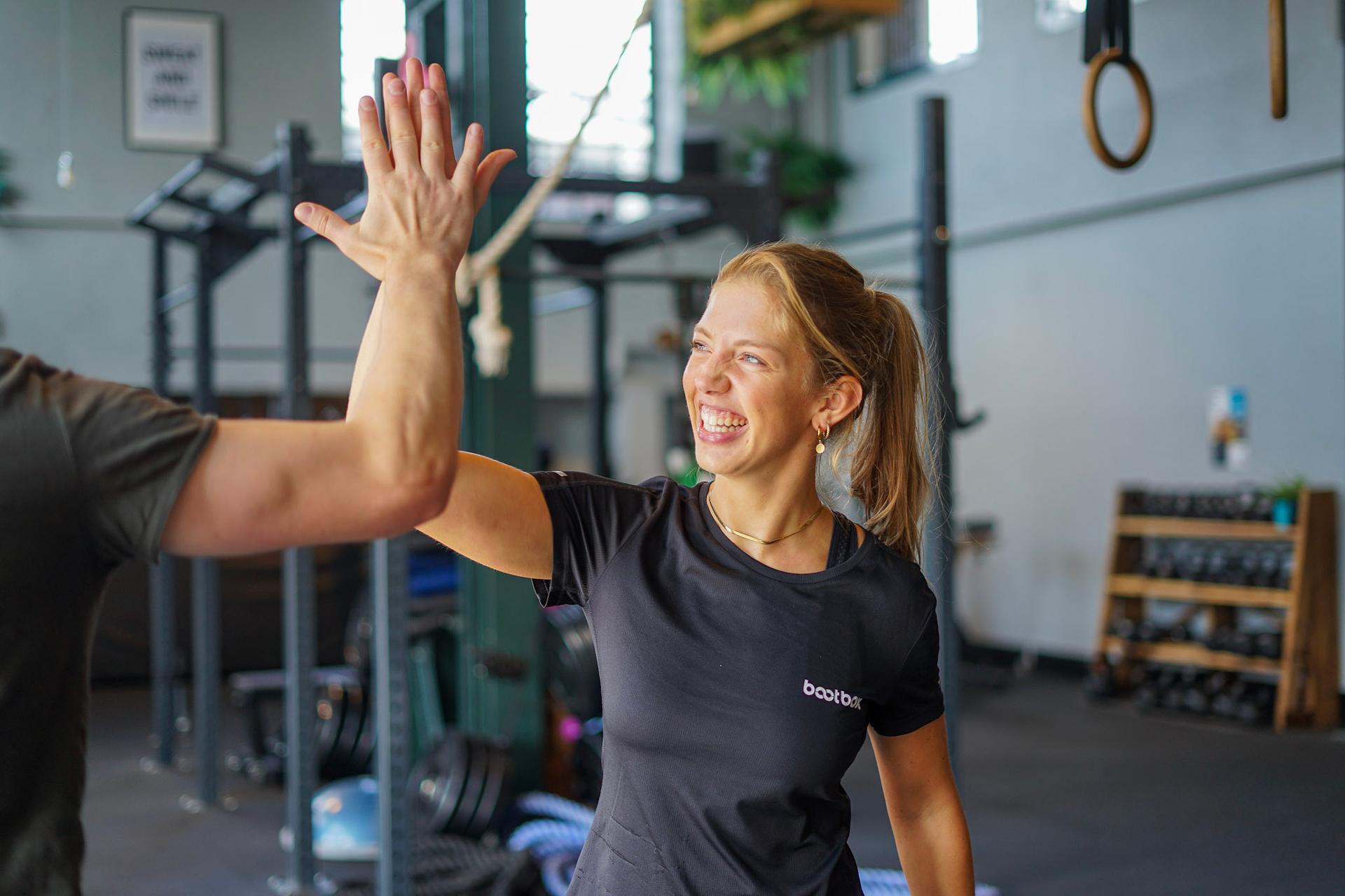 Personal Training Kundin freut sich auf das Workout im Fitnessstudio in Köln.