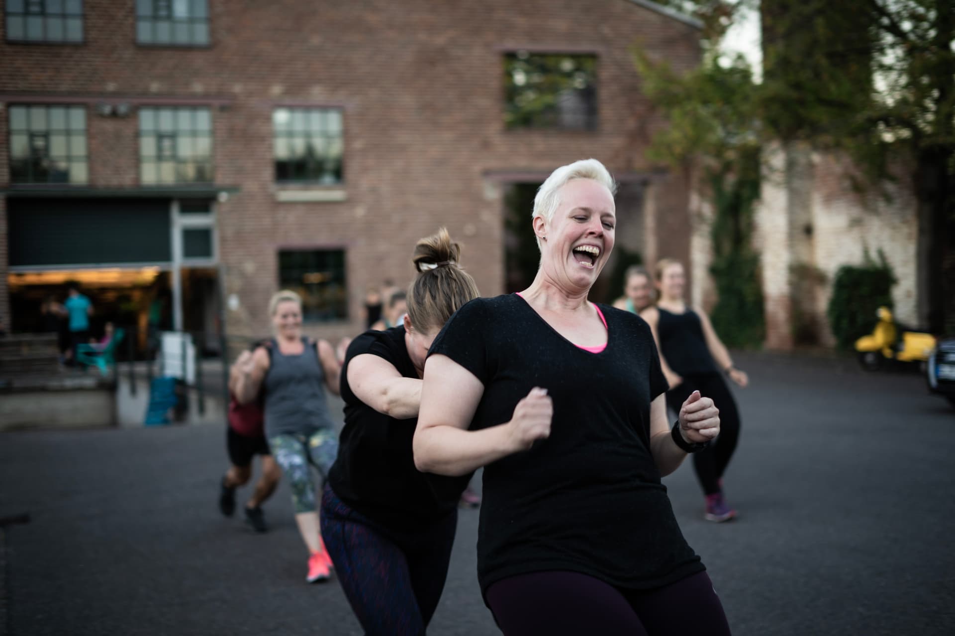 Eine Frau schiebt eine andere Frau über den Bootbox Innenhof