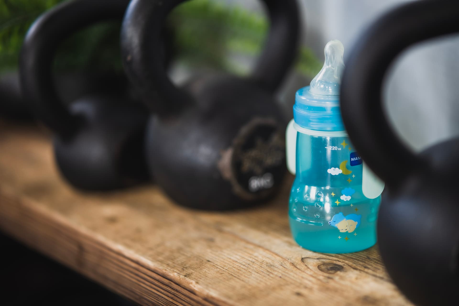 Trinkflasche von Baby steht im Regal mit Kettlebells in Bootboxbox Köln Ehrenfeld