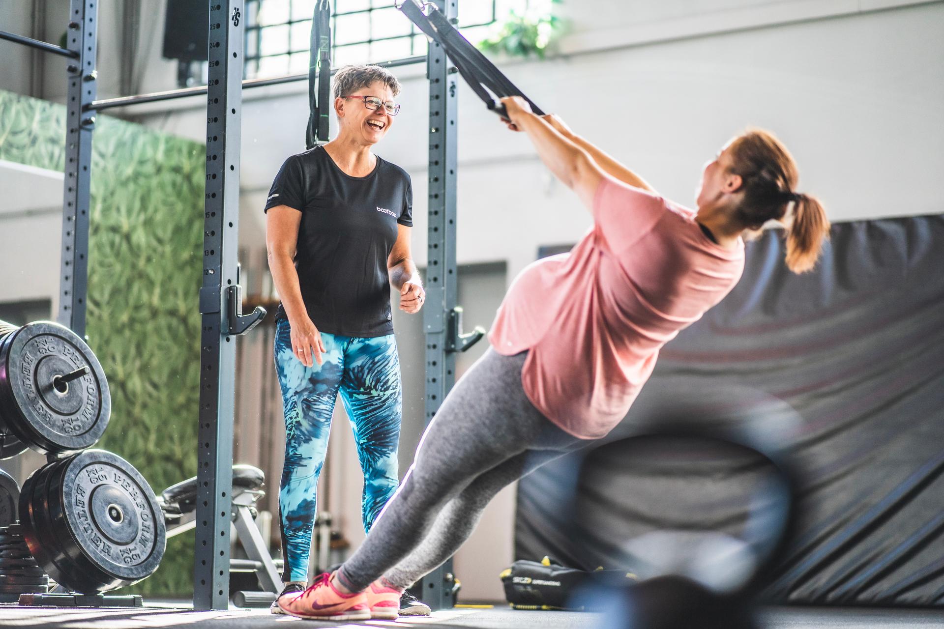 Kursteilnehmerin rudert am TRX-Band im Fit Mum Kurs der Bootbox Köln Ehrenfeld